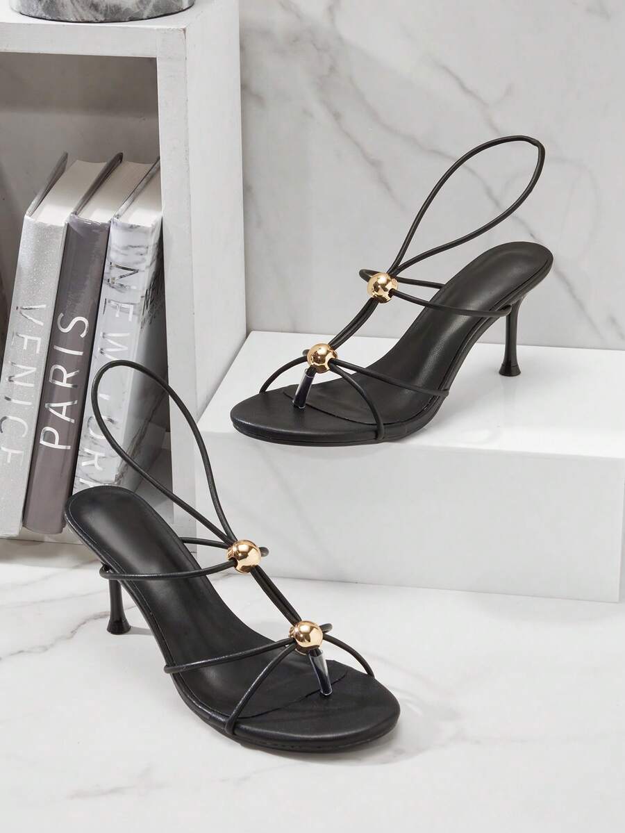 Women's strappy stiletto heel sandals crafted in vegan PU leather featuring open toe design and metallic bead accents.