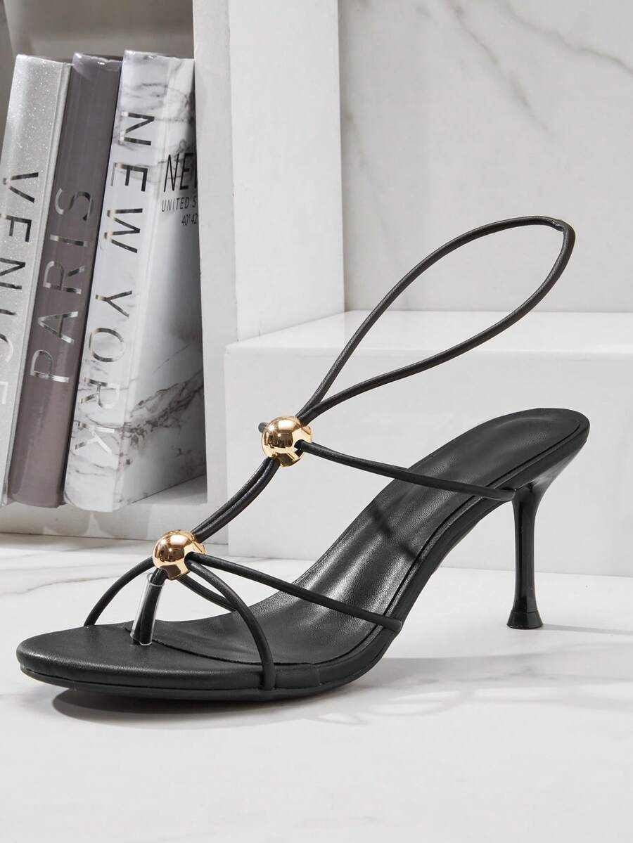 Women's strappy stiletto heel sandals crafted in vegan PU leather featuring open toe design and metallic bead accents.