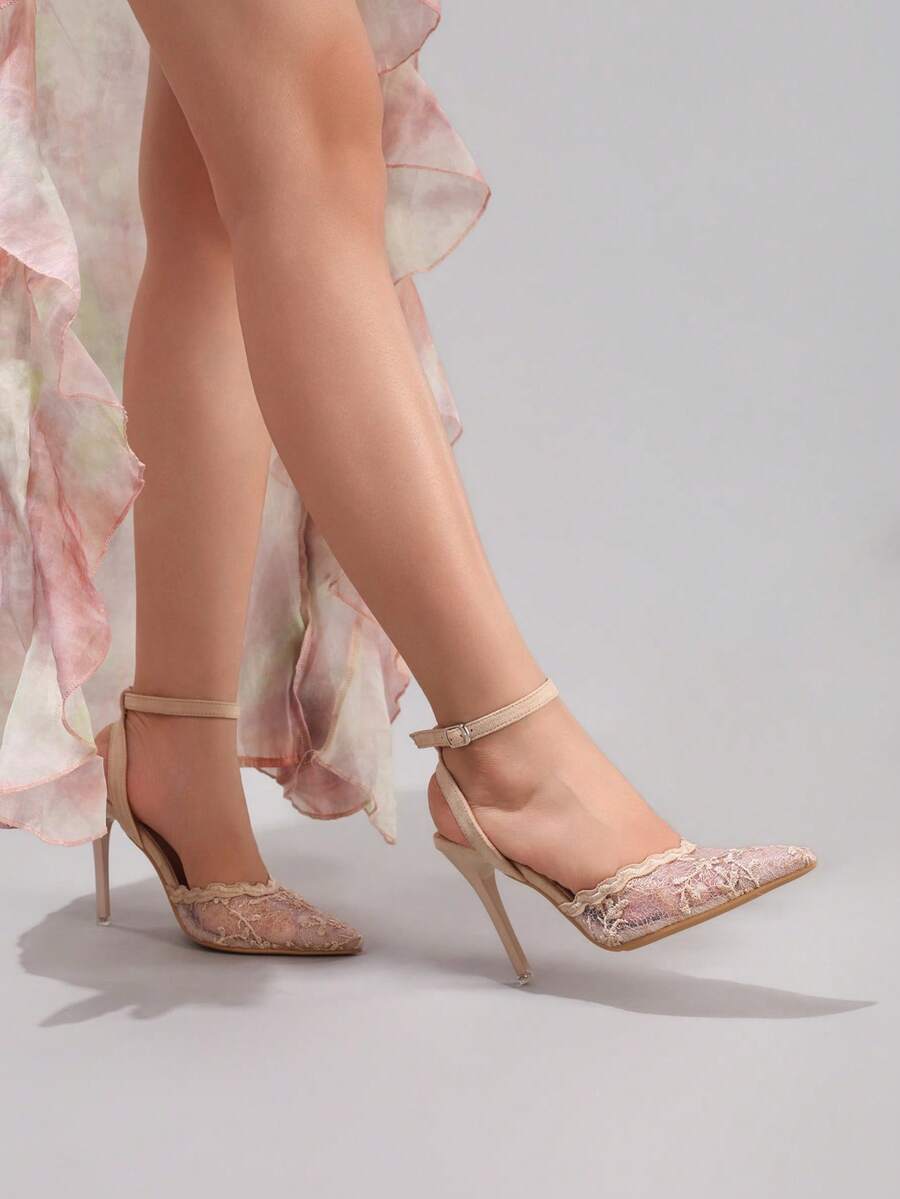 Lace embroidered high heels with thin stiletto heel, pointed toe, rhinestone embellishments, and ankle strap buckle closure.
