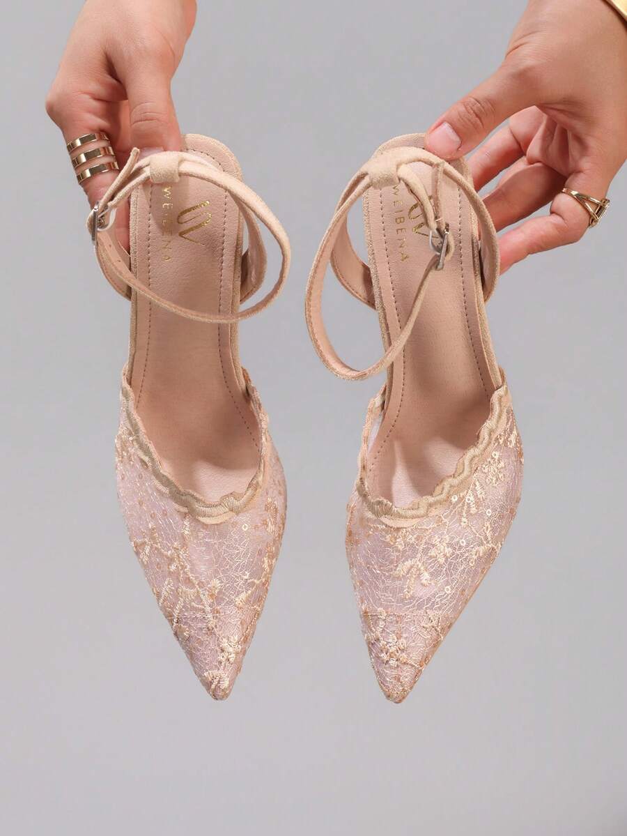 Lace embroidered high heels with thin stiletto heel, pointed toe, rhinestone embellishments, and ankle strap buckle closure.