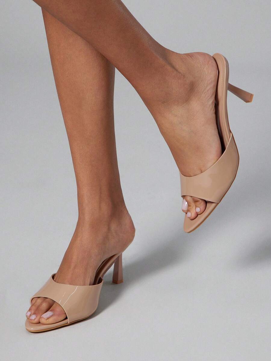Black pointy toe kitten heel shoes for women featuring a sleek cut out mule design and glossy patent leather finish.