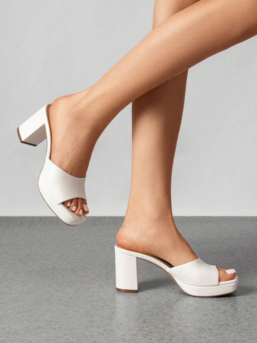 Women's minimalist open toe mule sandals featuring a chunky low heel, wide single strap, and slip-on design.