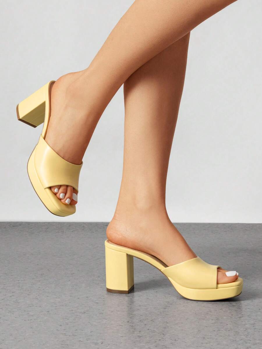 Women's minimalist open toe mule sandals featuring a chunky low heel, wide single strap, and slip-on design.