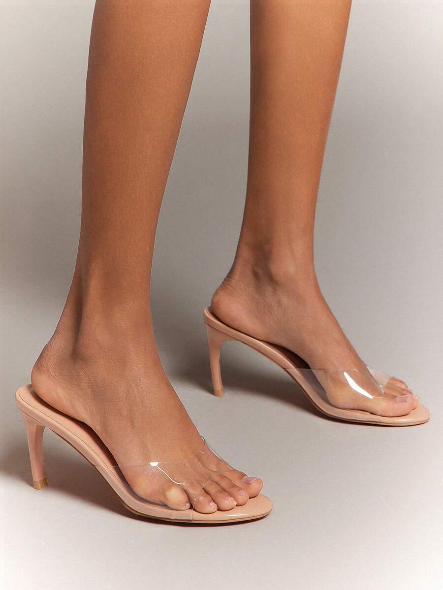 Black pointy toe kitten heel shoes for women featuring a sleek cut out mule design and glossy patent leather finish.