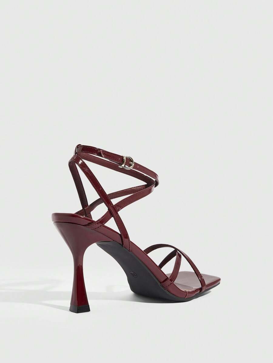 Women's kitten heel sandals featuring criss-cross straps with buckle closure and an open toe design.