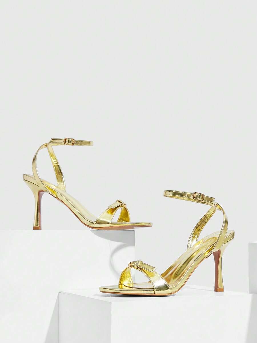 Pair of women's black high heel sandals with open toe design, slim stiletto heel, and adjustable ankle buckle strap.