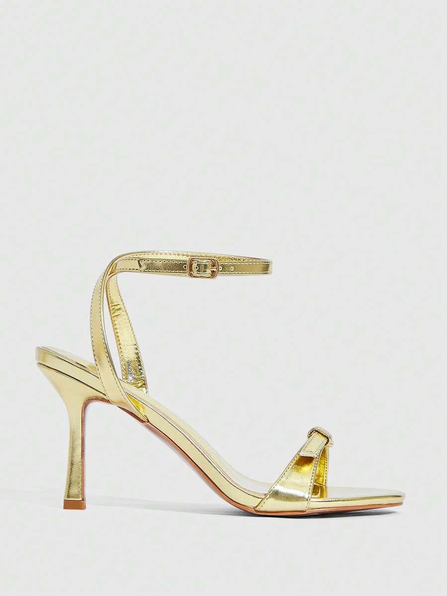 Pair of women's black high heel sandals with open toe design, slim stiletto heel, and adjustable ankle buckle strap.