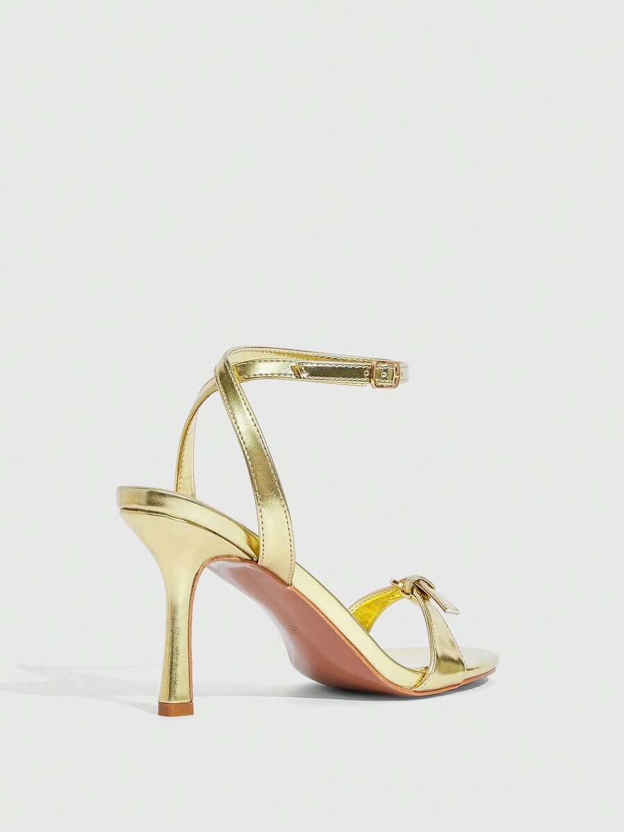 Pair of women's black high heel sandals with open toe design, slim stiletto heel, and adjustable ankle buckle strap.