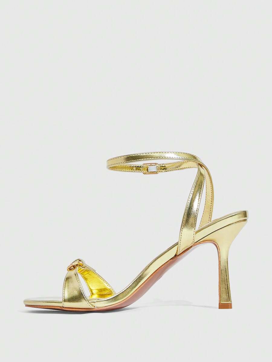 Pair of women's black high heel sandals with open toe design, slim stiletto heel, and adjustable ankle buckle strap.