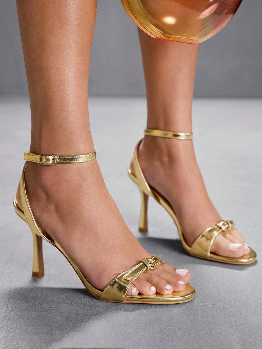 Pair of women's black high heel sandals with open toe design, slim stiletto heel, and adjustable ankle buckle strap.