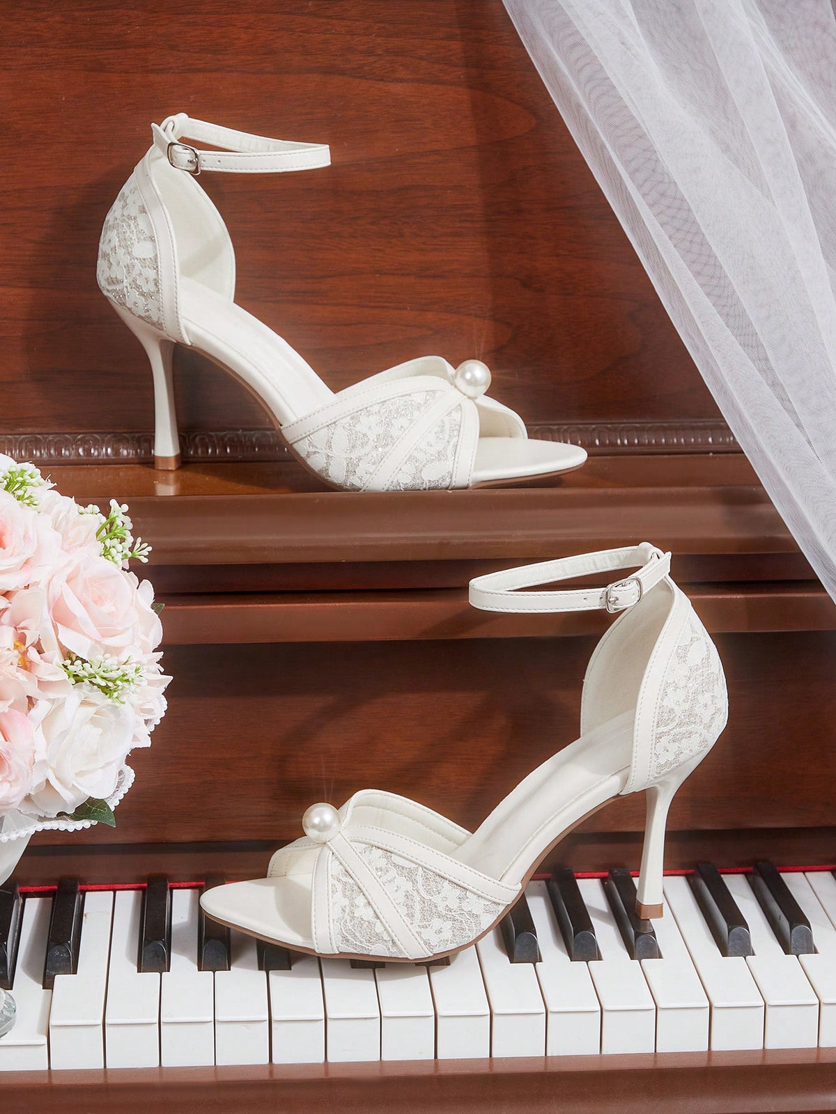 Beige high heel sandals with delicate lace overlay, pearl embellishments, stiletto heel, and adjustable ankle strap for bride and wedding party wear.