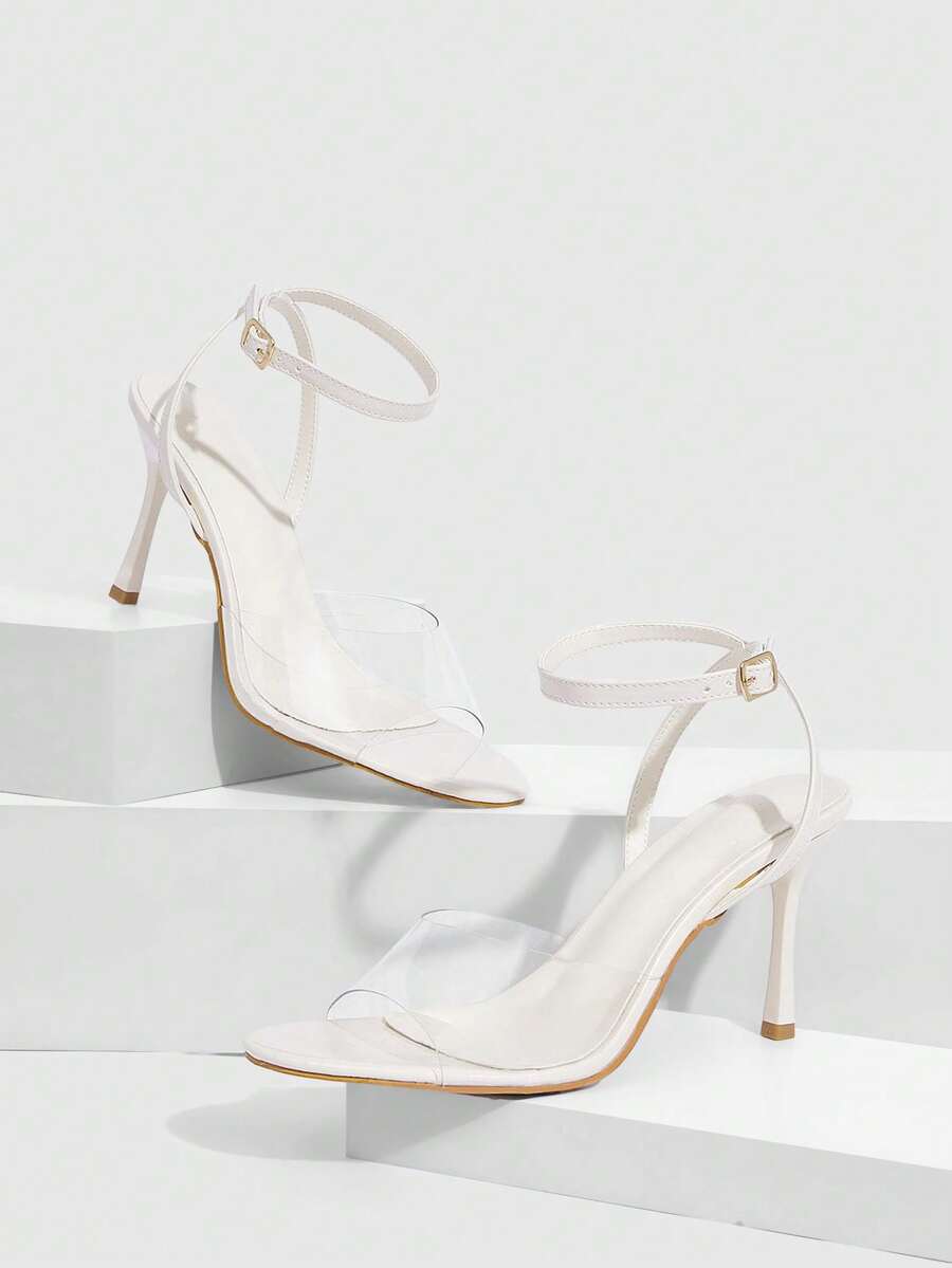 Pair of women's black high heel sandals with open toe design, slim stiletto heel, and adjustable ankle buckle strap.