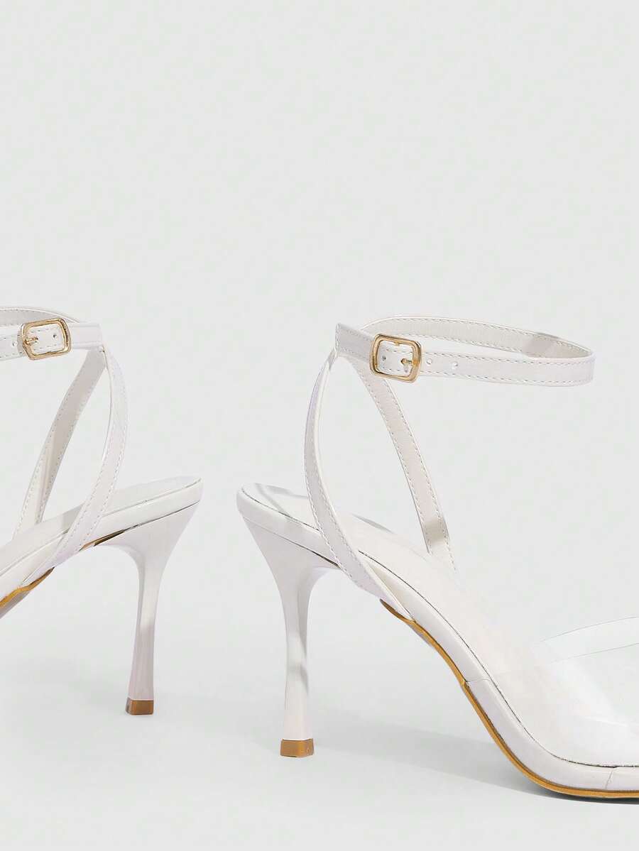 Pair of women's black high heel sandals with open toe design, slim stiletto heel, and adjustable ankle buckle strap.