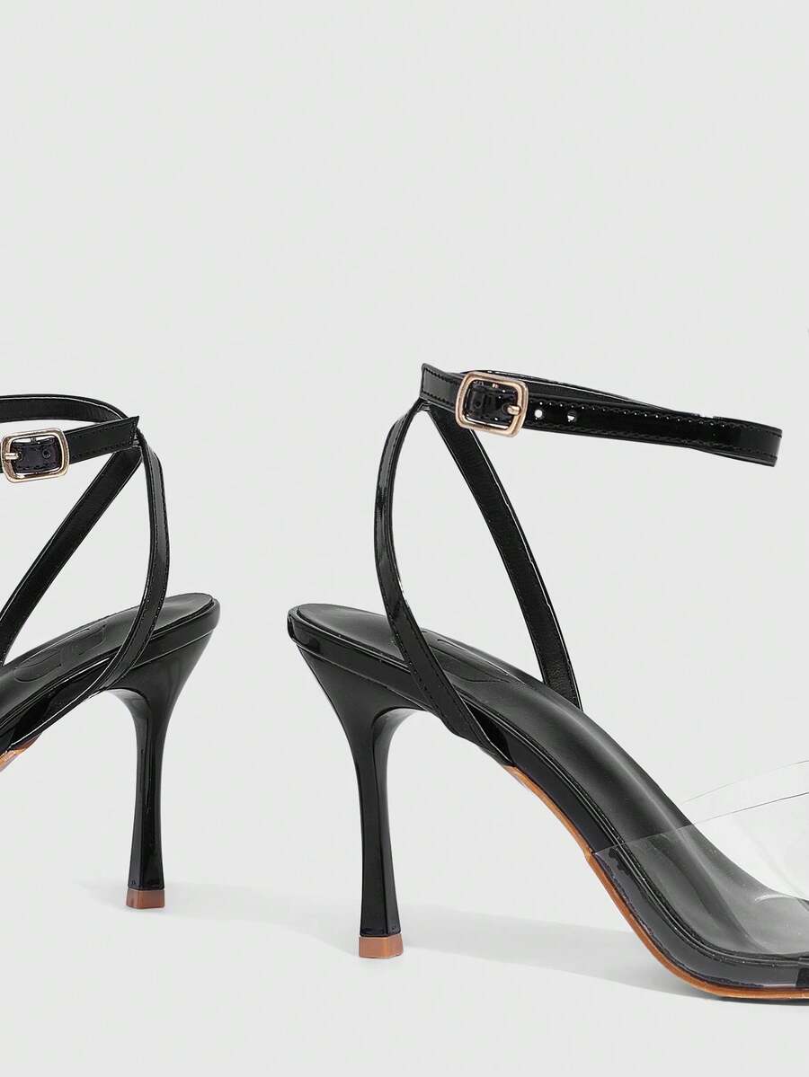 Pair of women's black high heel sandals with open toe design, slim stiletto heel, and adjustable ankle buckle strap.