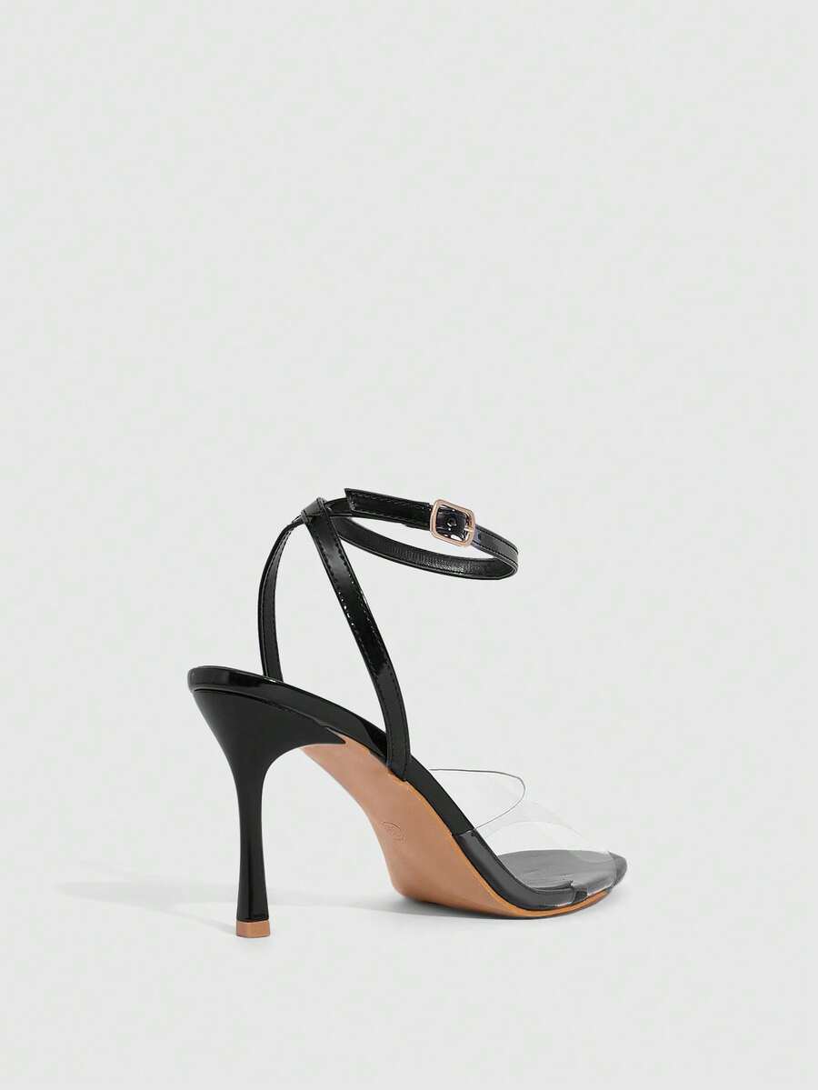 Pair of women's black high heel sandals with open toe design, slim stiletto heel, and adjustable ankle buckle strap.