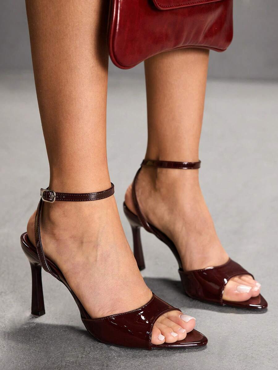 Minimalist women's open toe high heel sandals featuring a slender stiletto heel and adjustable ankle strap buckle closure.