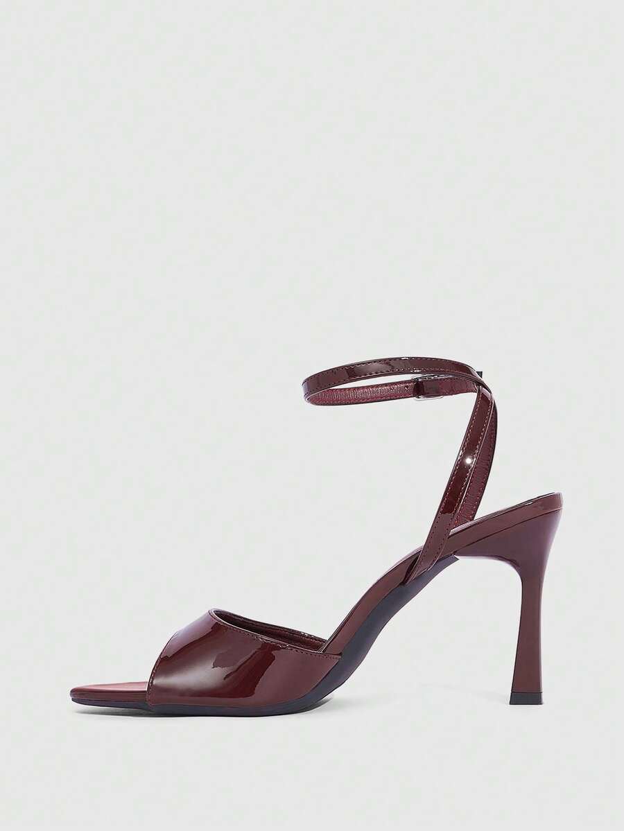 Minimalist women's open toe high heel sandals featuring a slender stiletto heel and adjustable ankle strap buckle closure.
