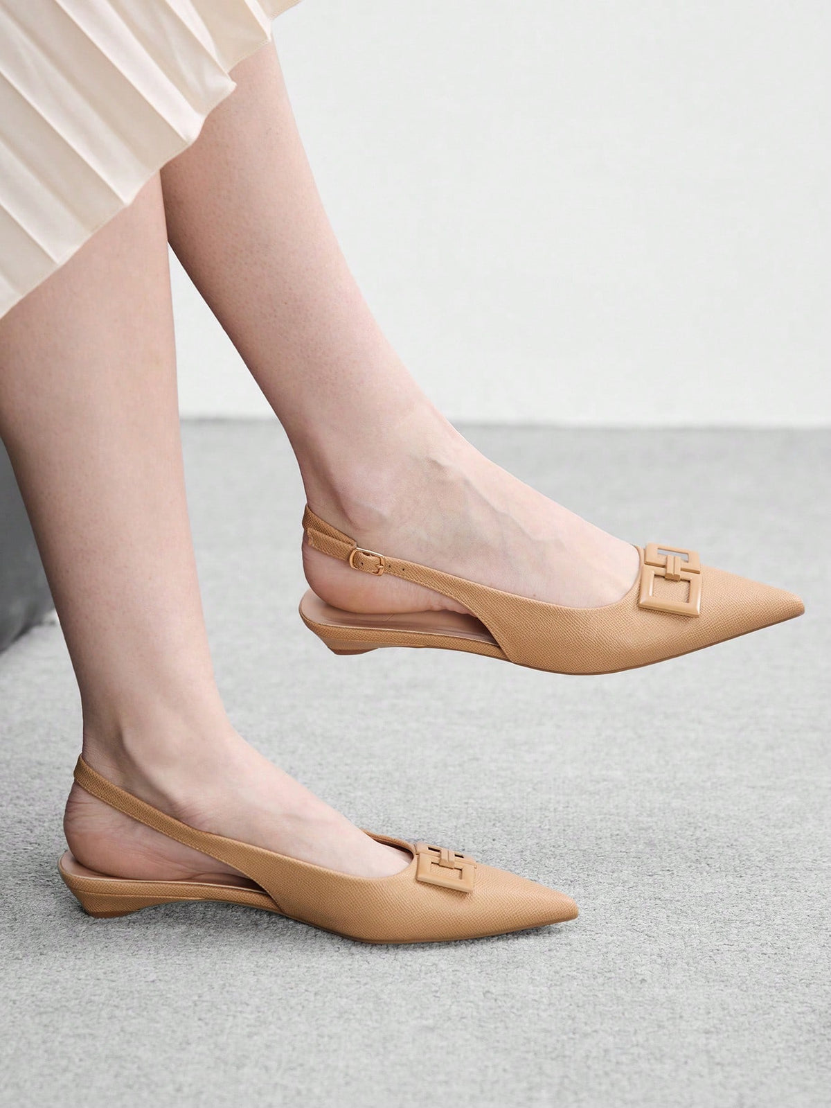 Women's pointed toe low wedge flat shoes crafted in PU leather with a slingback strap and stylish metal buckle detail.