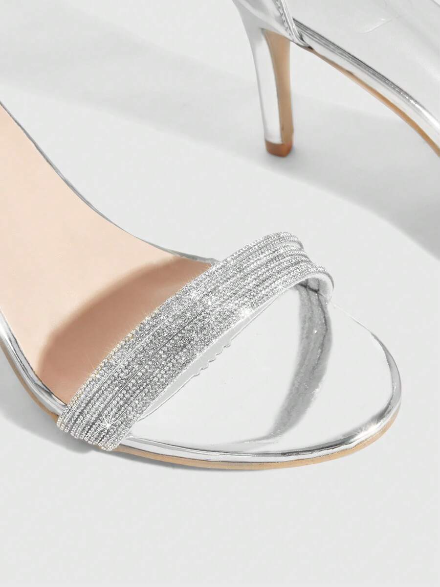 Women's pointed toe high heel sandals with sparkling rhinestone ankle straps and stiletto heels for evening and party wear.