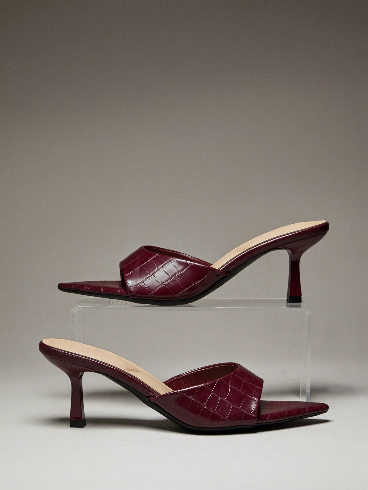 Black pointy toe kitten heel shoes for women featuring a sleek cut out mule design and glossy patent leather finish.