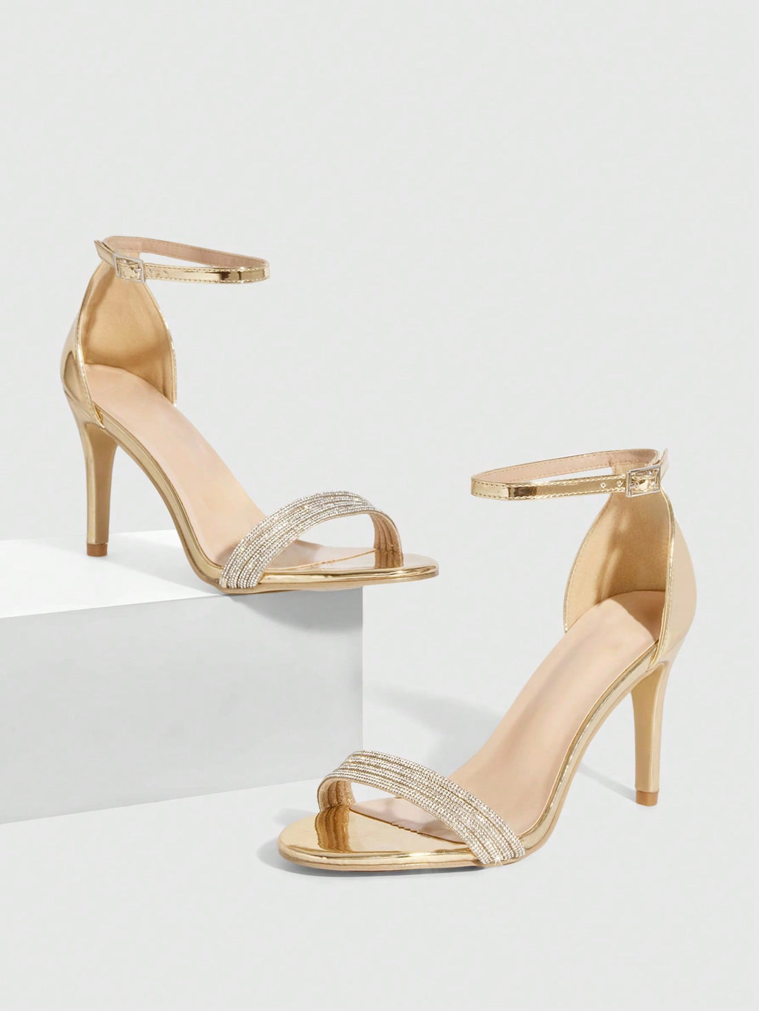Women's pointed toe high heel sandals with sparkling rhinestone ankle straps and stiletto heels for evening and party wear.