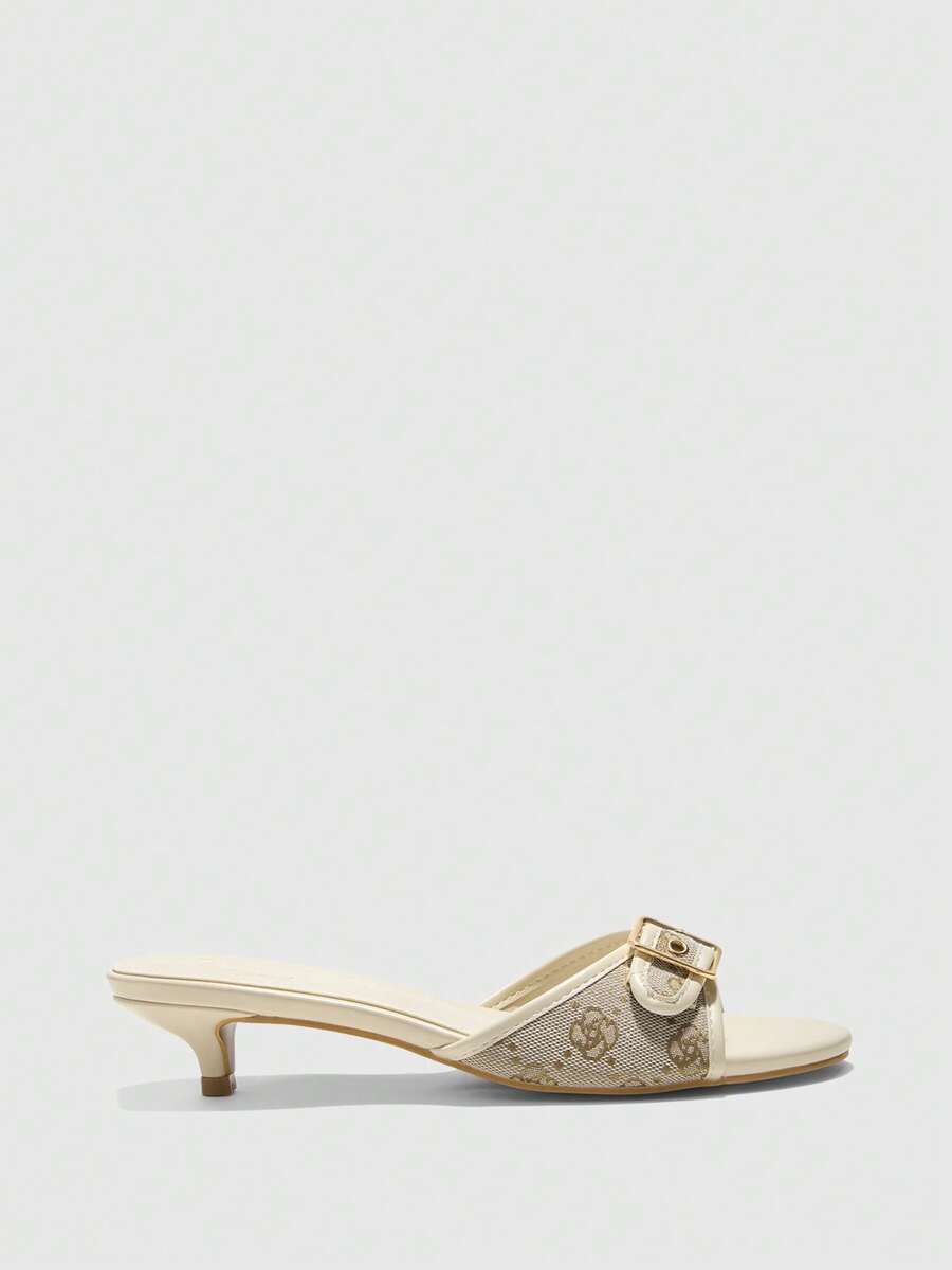 Beige women's slip-on kitten heel slide sandals featuring an accent buckle with grommet eyelets.