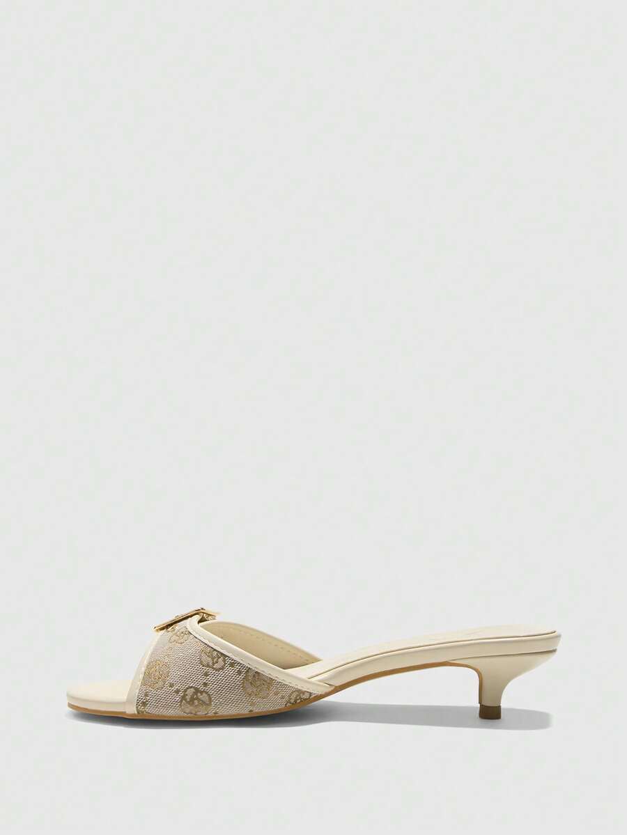 Beige women's slip-on kitten heel slide sandals featuring an accent buckle with grommet eyelets.