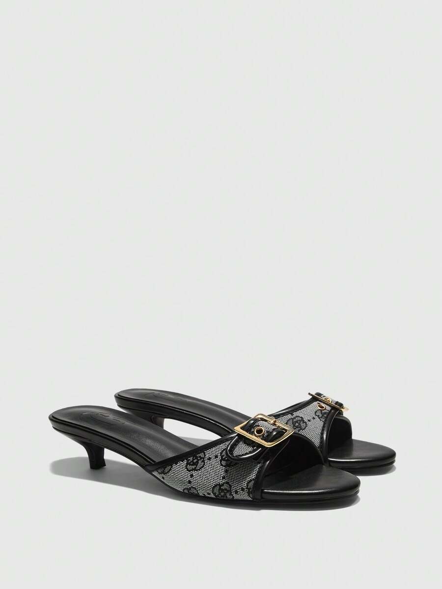 Beige women's slip-on kitten heel slide sandals featuring an accent buckle with grommet eyelets.