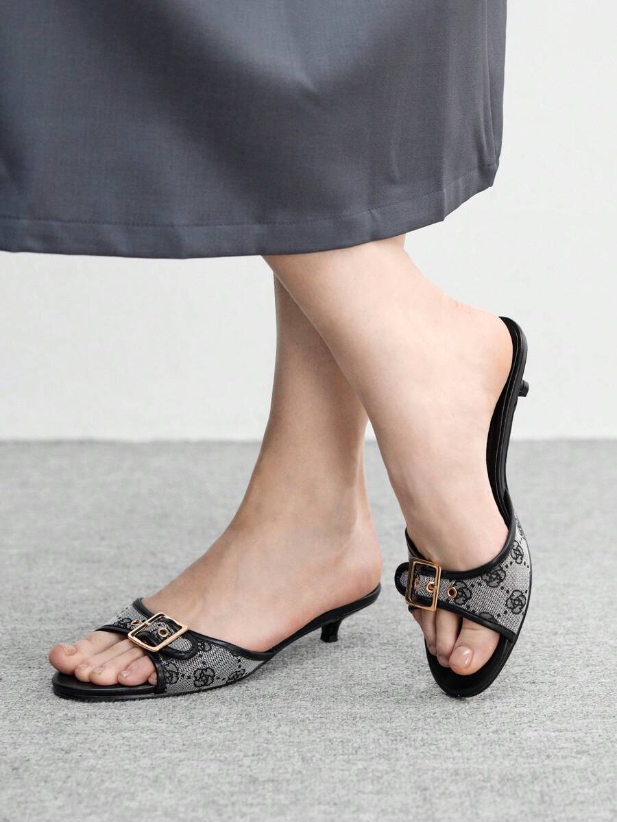 Beige women's slip-on kitten heel slide sandals featuring an accent buckle with grommet eyelets.