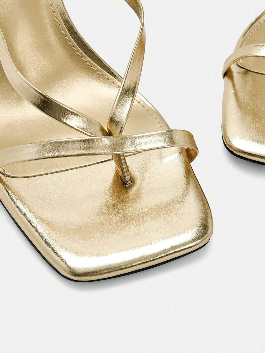 Women's gold strappy high heel sandals featuring a square open toe, stiletto heel, criss-cross ankle straps with buckle closure, and toe post design.