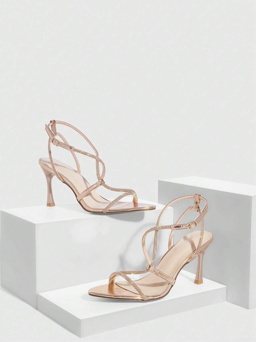 Women's pointed toe high heel sandals embellished with sparkling rhinestones, stiletto heels, and ankle strap buckle closure.