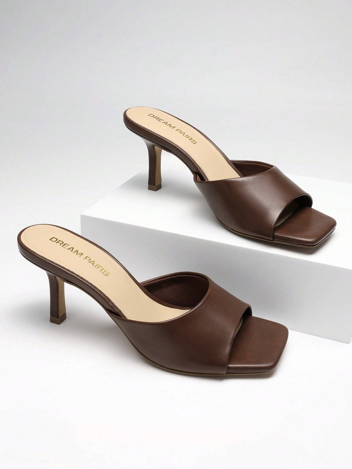 Pair of women's open square toe kitten heel mule sandals in white PU leather with slip-on styling.