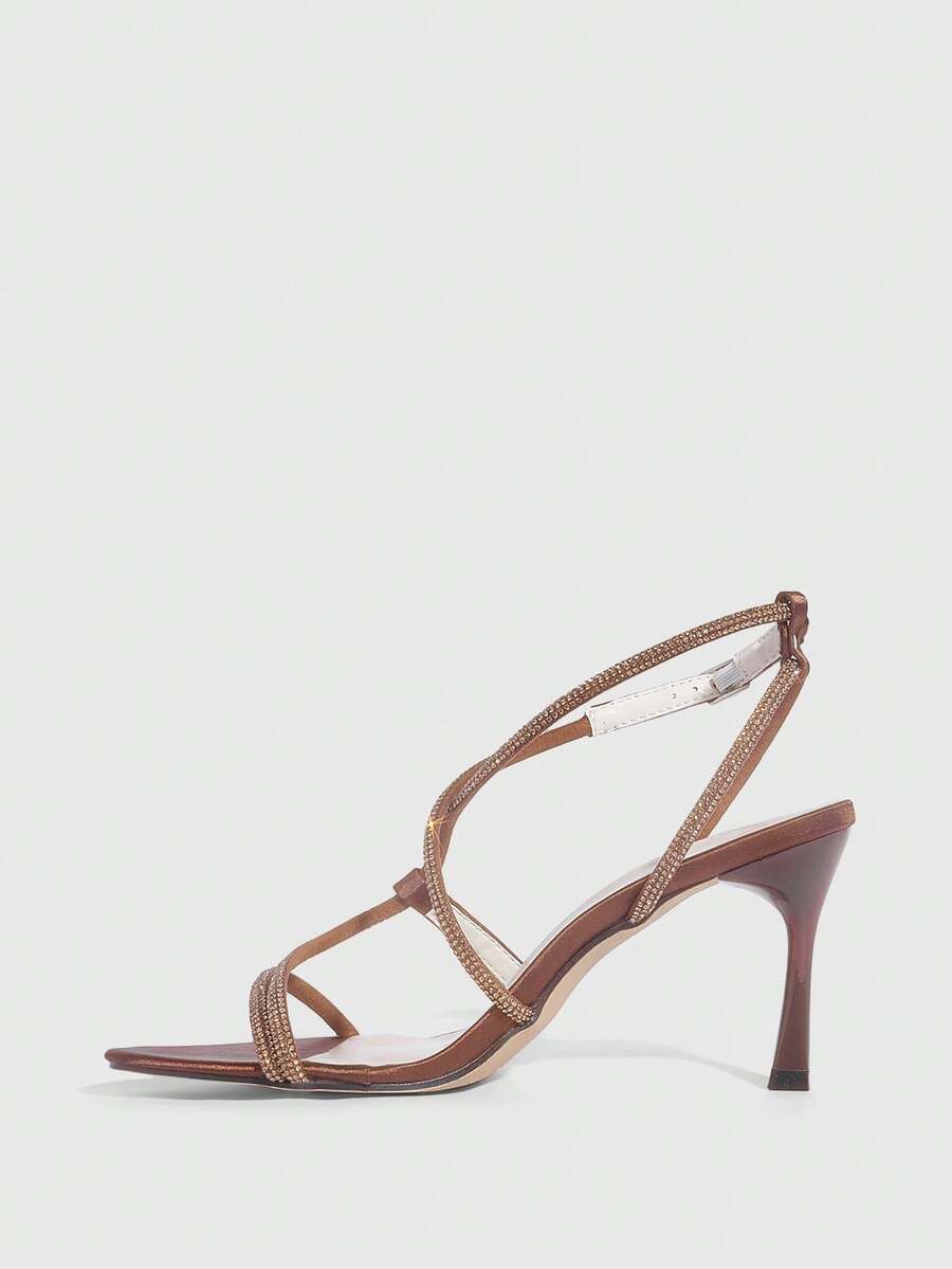 Women's pointed toe high heel sandals embellished with sparkling rhinestones, stiletto heels, and ankle strap buckle closure.