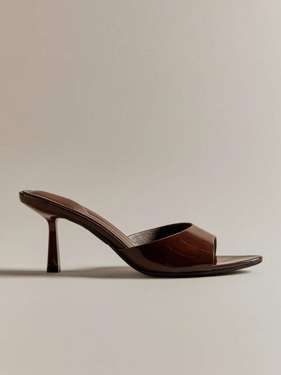 Pair of women's minimalist black pointy toe stiletto heel sandals with slingback straps.