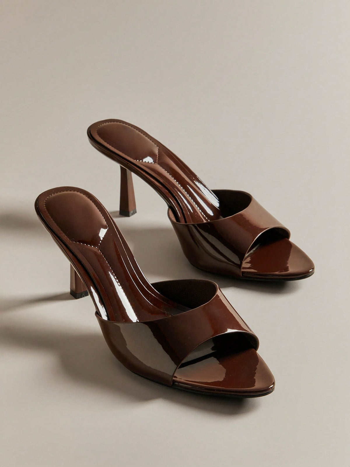 Pair of women's minimalist black pointy toe stiletto heel sandals with slingback straps.