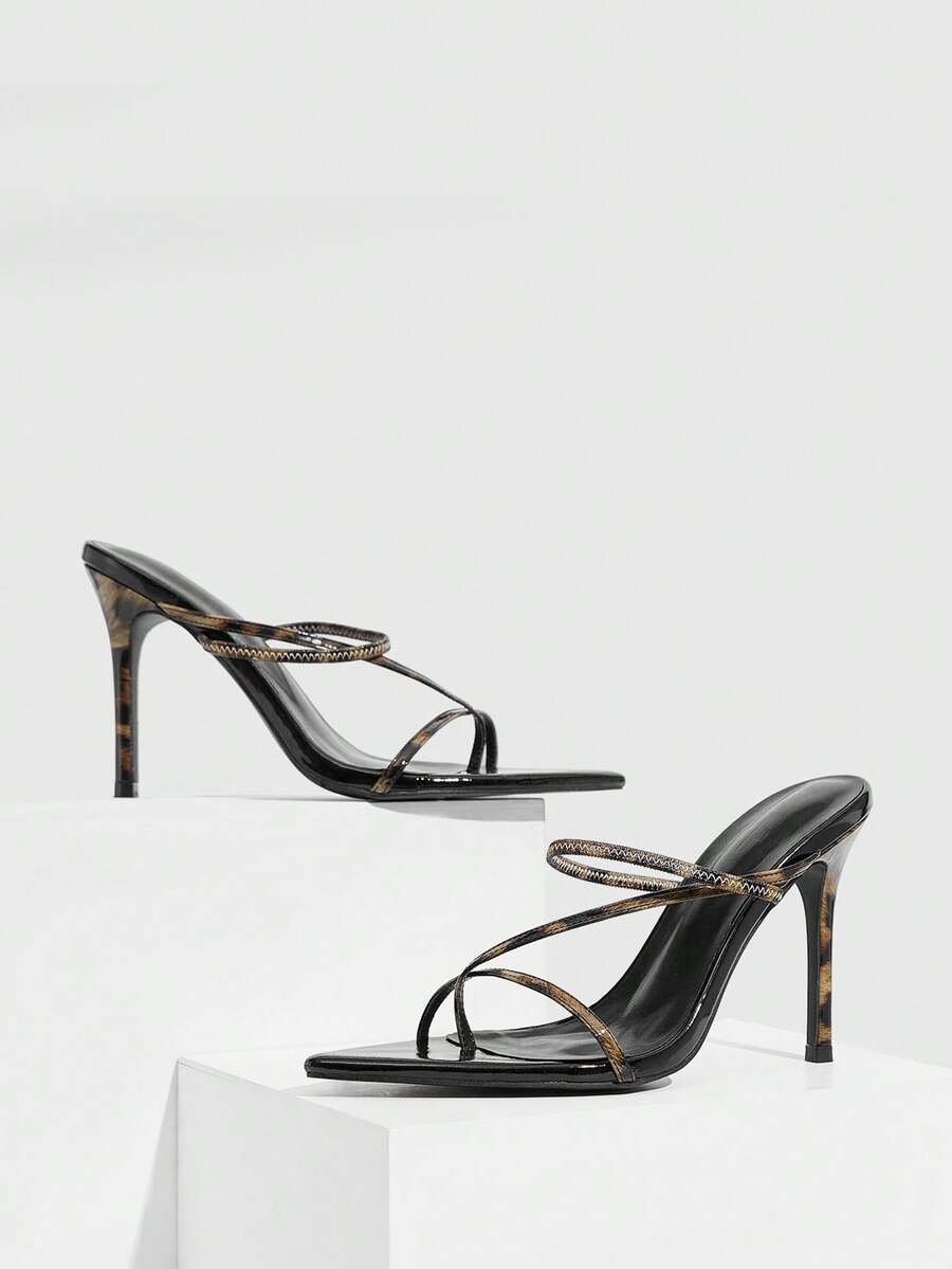 Women's pointed toe heeled sandals with criss cross straps and high stiletto heels.