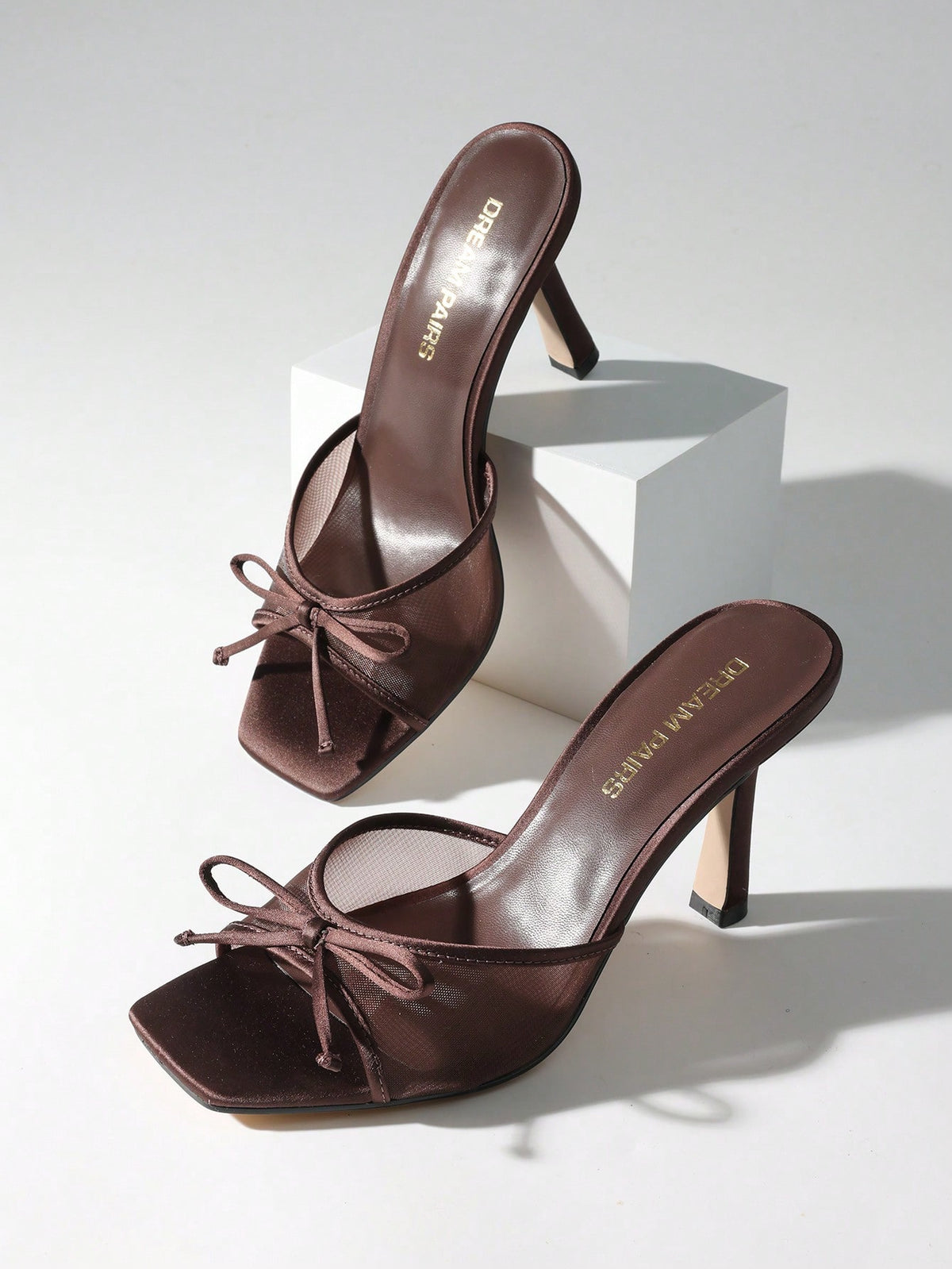 Women's open toe stiletto mule sandals featuring a breathable mesh upper with a decorative bow and square toe design.