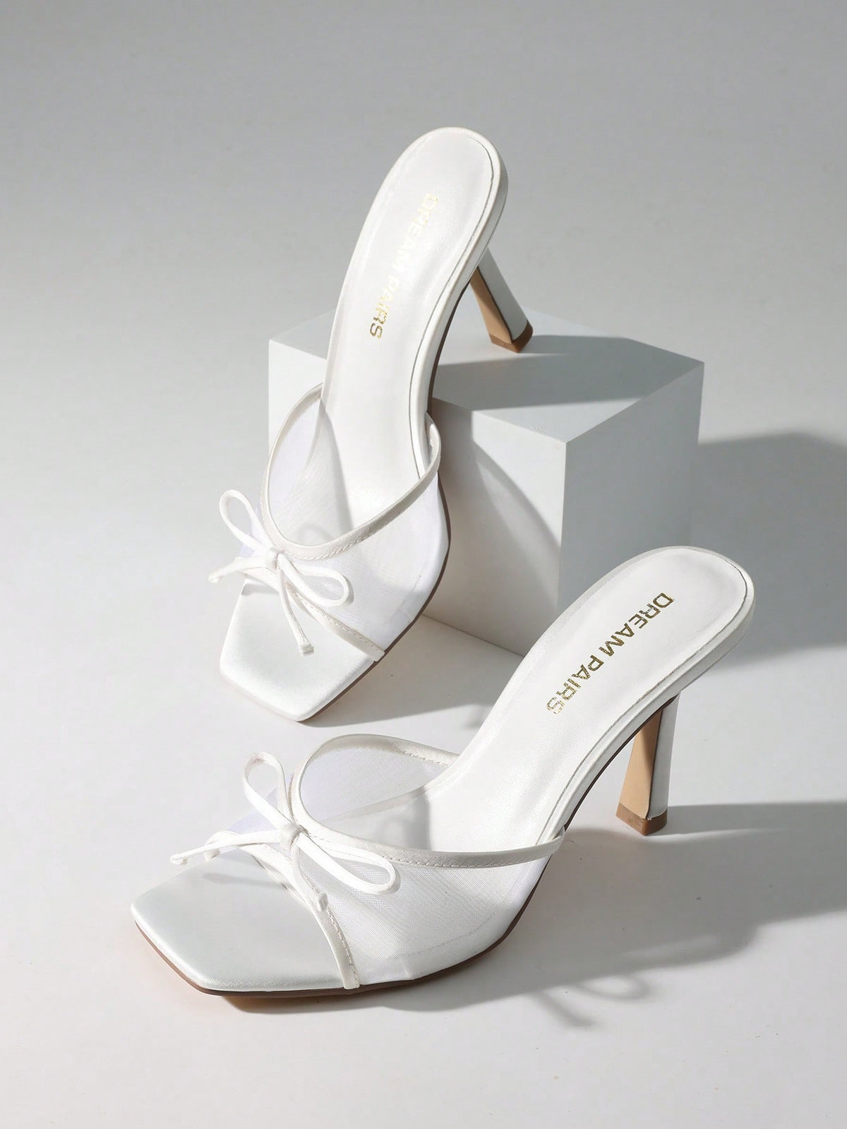Women's open toe stiletto mule sandals featuring a breathable mesh upper with a decorative bow and square toe design.