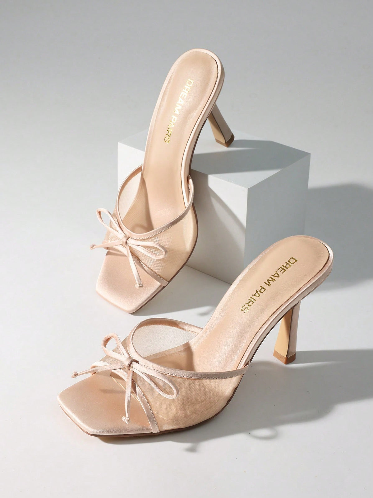 Women's open toe stiletto mule sandals featuring a breathable mesh upper with a decorative bow and square toe design.