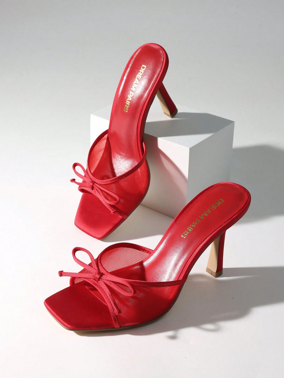 Women's open toe stiletto mule sandals featuring a breathable mesh upper with a decorative bow and square toe design.