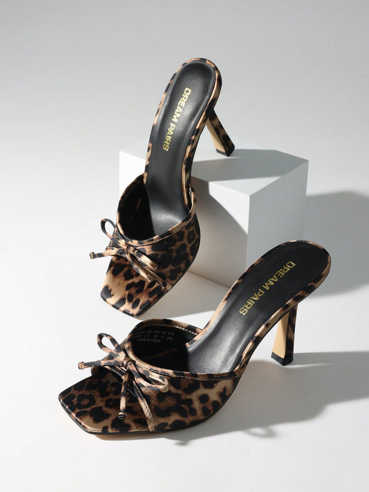 Women's open toe stiletto mule sandals featuring a breathable mesh upper with a decorative bow and square toe design.
