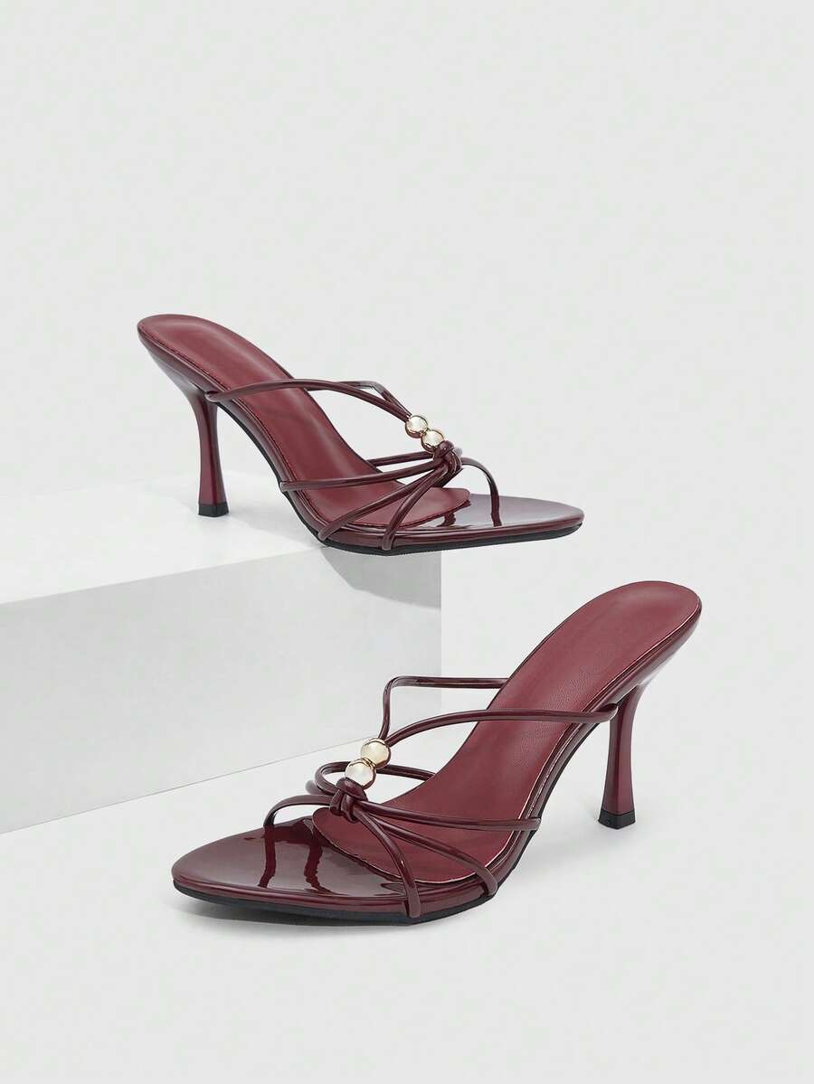 Burgundy stiletto high heel sandals featuring open toe thin straps and knot details