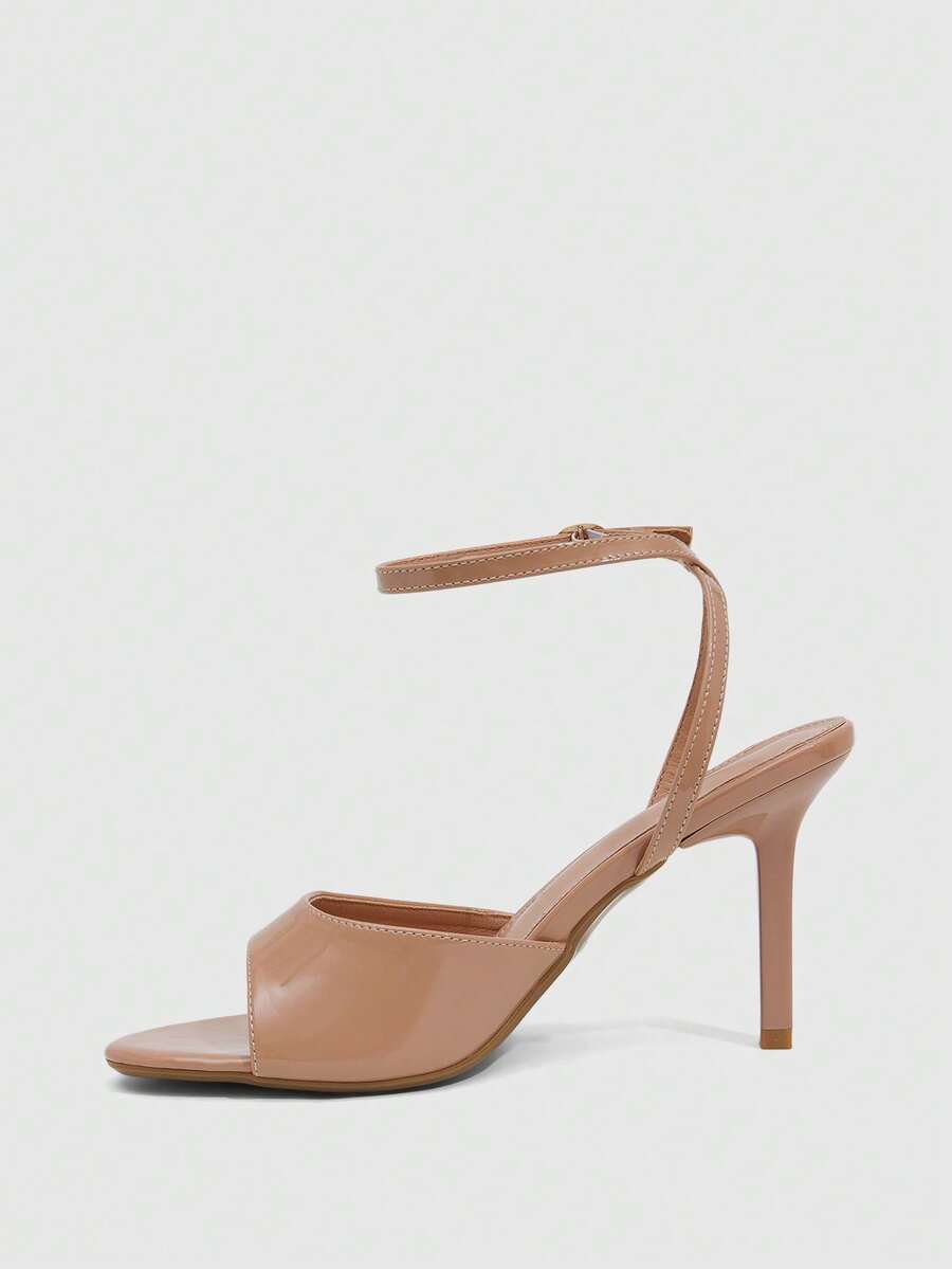 Women's pointed peep toe high heel stilettos featuring cross ankle strap with buckle in black PU leather.