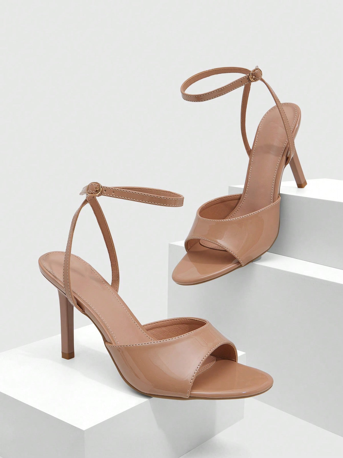 Women's pointed peep toe high heel stilettos featuring cross ankle strap with buckle in black PU leather.