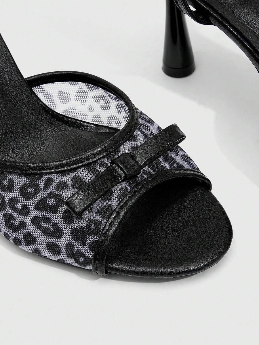 Pair of women's black high heel sandals with open toe design, slim stiletto heel, and adjustable ankle buckle strap.
