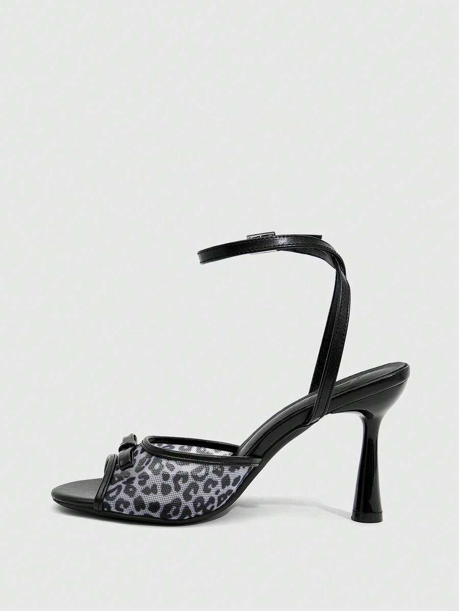 Pair of women's black high heel sandals with open toe design, slim stiletto heel, and adjustable ankle buckle strap.
