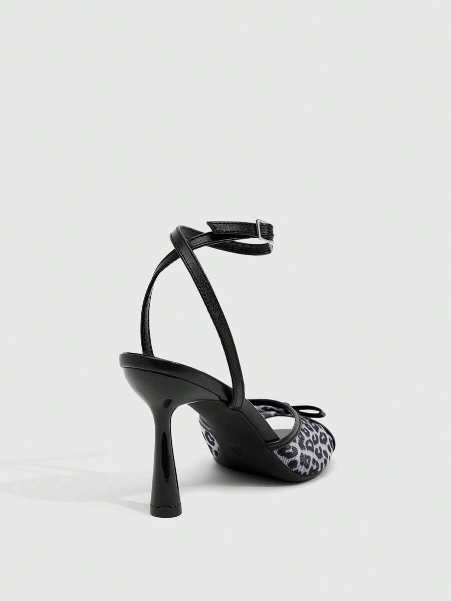 Pair of women's black high heel sandals with open toe design, slim stiletto heel, and adjustable ankle buckle strap.