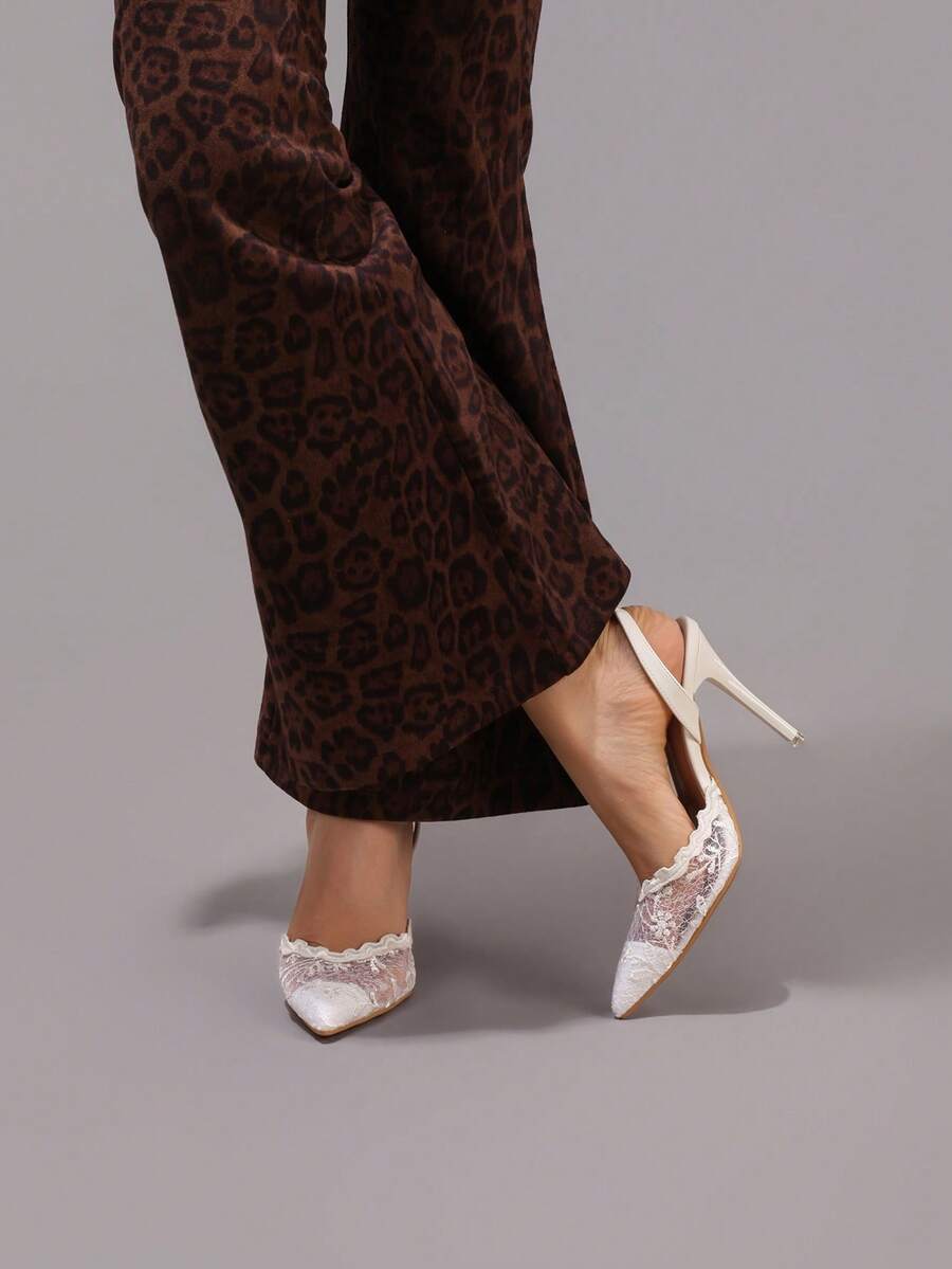Lace embroidered high heels with thin stiletto heel, pointed toe, rhinestone embellishments, and ankle strap buckle closure.