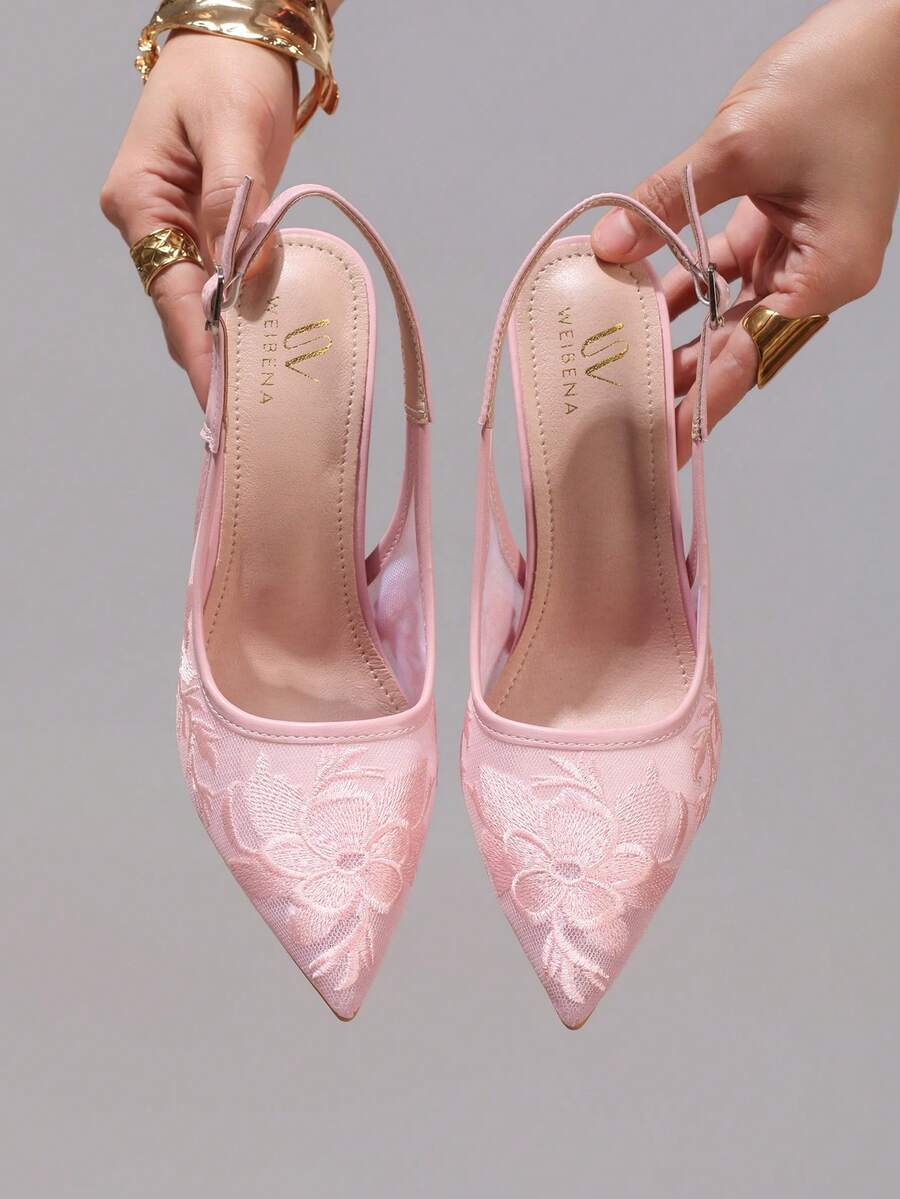 Lace embroidered high heels with thin stiletto heel, pointed toe, rhinestone embellishments, and ankle strap buckle closure.