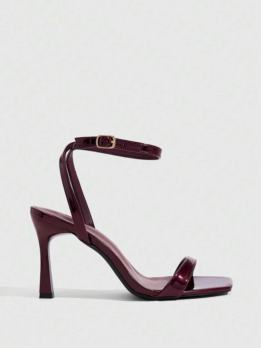 Women's high heel ankle strap sandals with open toe and stiletto heel in mirror black finish.